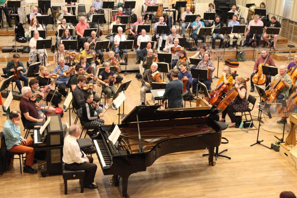 Ensemble director leading a rehearsal before a performance tour